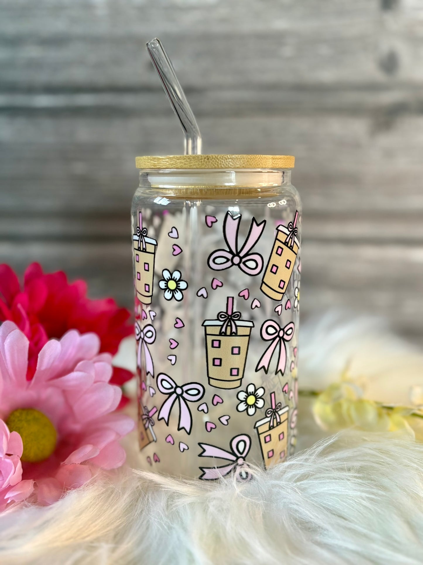 Tumbler with decorative design on a wooden surface with flowers