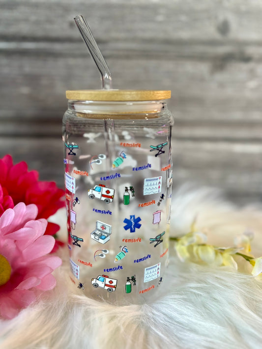 Clear glass jar with colorful illustrations and a wooden lid on a soft surface with flowers.